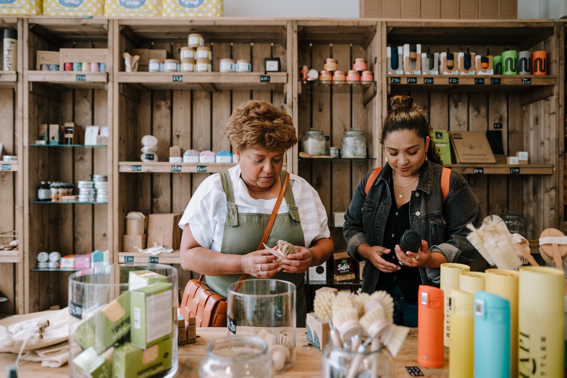 A companion helping an older woman choose household items while doing her shopping