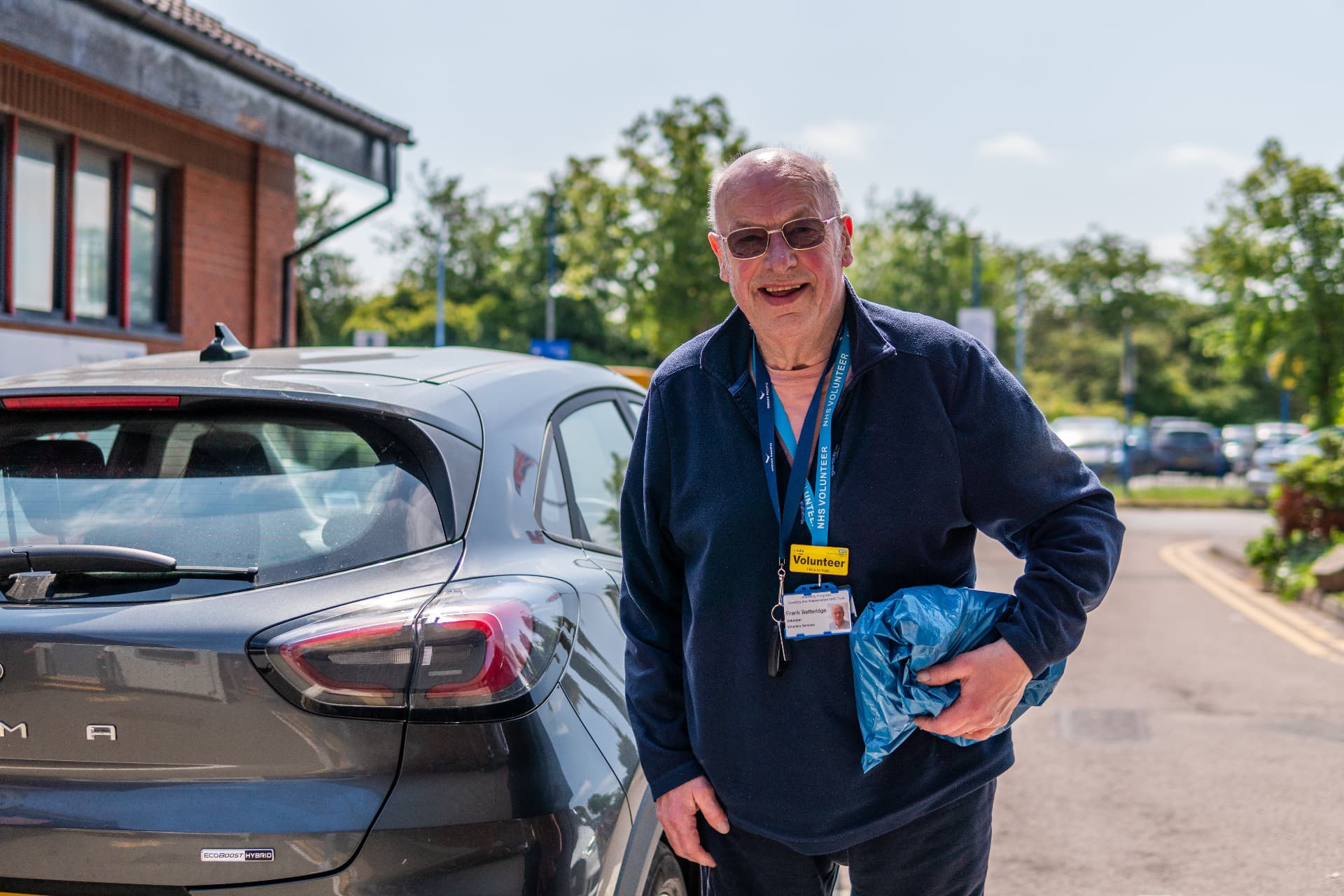 A Supreme Caring Services companion beside his car, ready to set off on a home visit in Hertfordshire